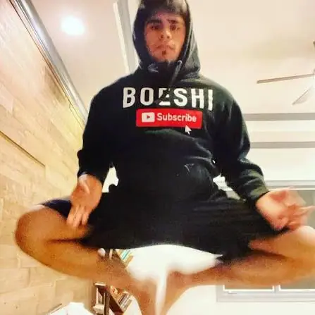 Boeshi before training seriously, sitting cross-legged in a BOESHI hoodie